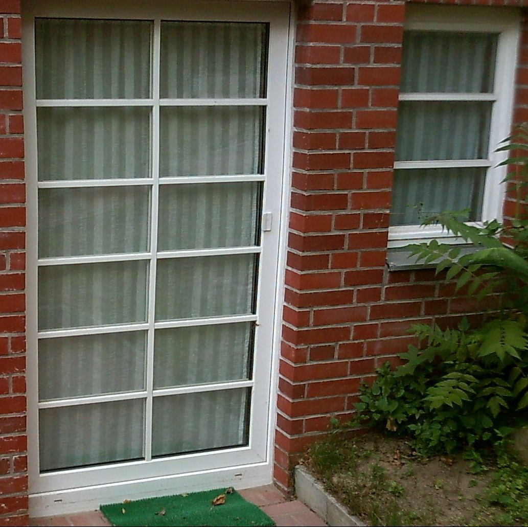 Weiße Haustür mit Sprossen und Glaseinsatz