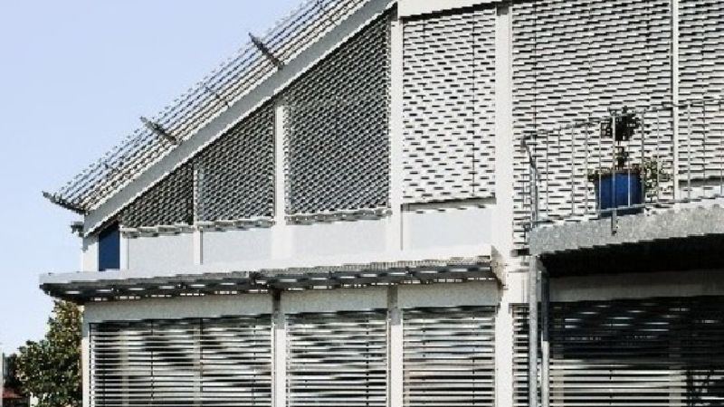 Haus mit Schrägdach und Jalousien vor jedem Fenster