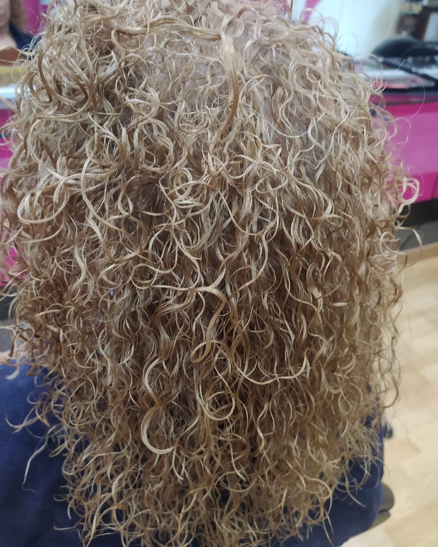 Cabello rubio rizado, primer plano. El foco es una persona con cabello largo y muy rizado.