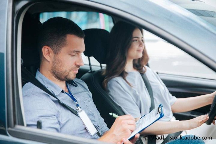 Ein Mann bringt einer Frau das Autofahren bei.