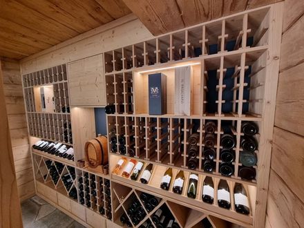 Une cuisine avec beaucoup d'armoires et d'étagères en bois dans un salon.