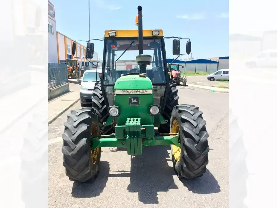 Un tractor John Deere verde está estacionado al costado de la carretera.