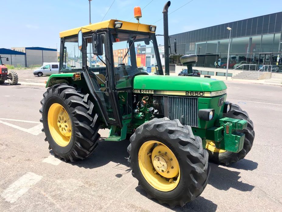 Un tractor John Deere verde y amarillo está estacionado en un estacionamiento.