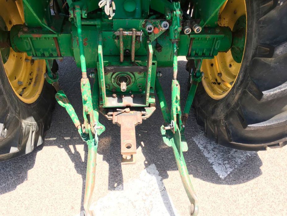 Un tractor verde y amarillo está estacionado al costado de la carretera.