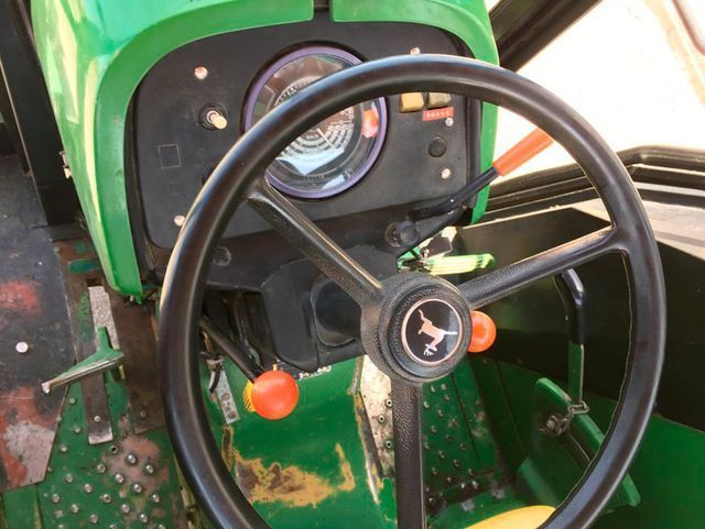 Un tractor verde con un volante negro.