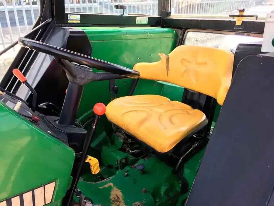 Un tractor verde con asiento y volante amarillos.