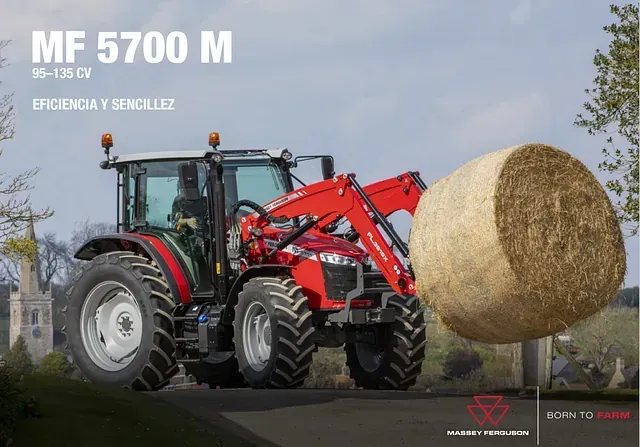 Un tractor rojo transporta un gran fardo de heno.