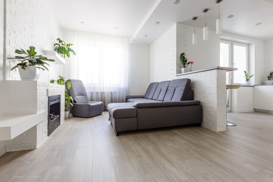 JK Fußbodenbau und Raumausstattung GmbH & Co. KG – ein Wohnzimmer mit Kaminofen. Hellgrauer Parkett ziert den Boden.