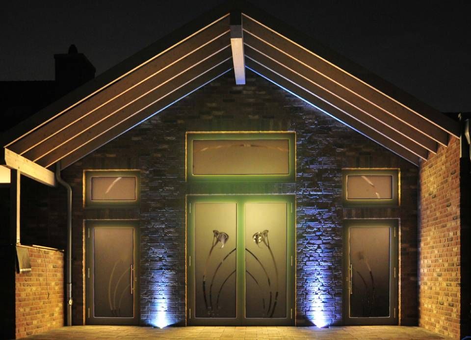 beleuchteter Eingangsbereich eines kleinen Hauses