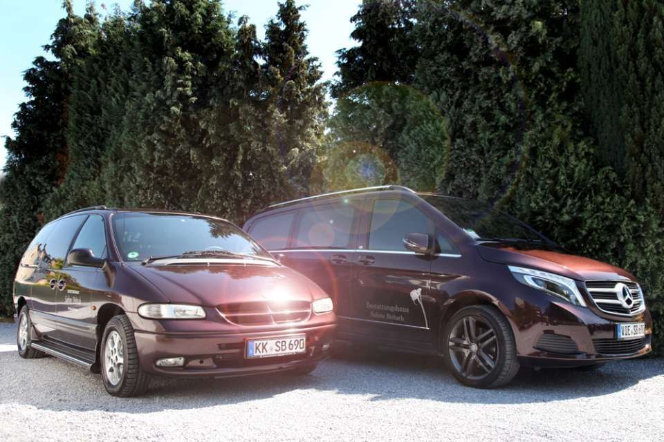 zwei dunkle Leichenwagen