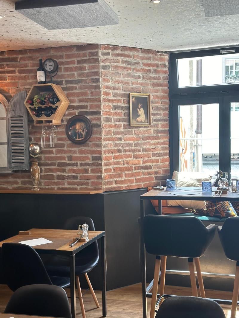 Ein Restaurant mit Tischen und Stühlen und einer Backsteinmauer