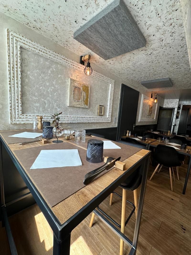 Ein Restaurant mit Tischen und Stühlen und einer Decke, die aussieht, als würde sie in der Luft schweben.