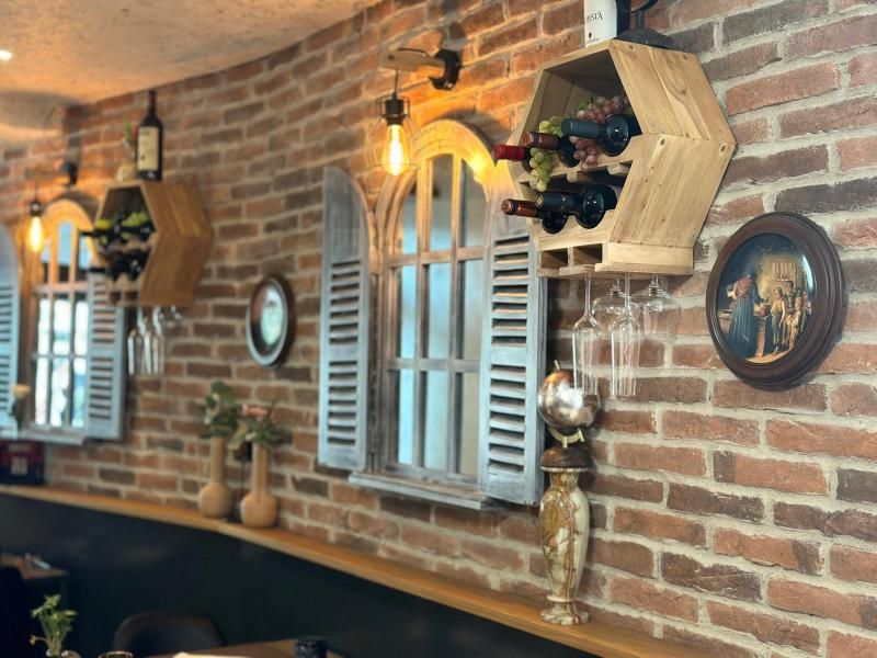 Eine Ziegelwand mit Weinflaschen und Gläsern darauf