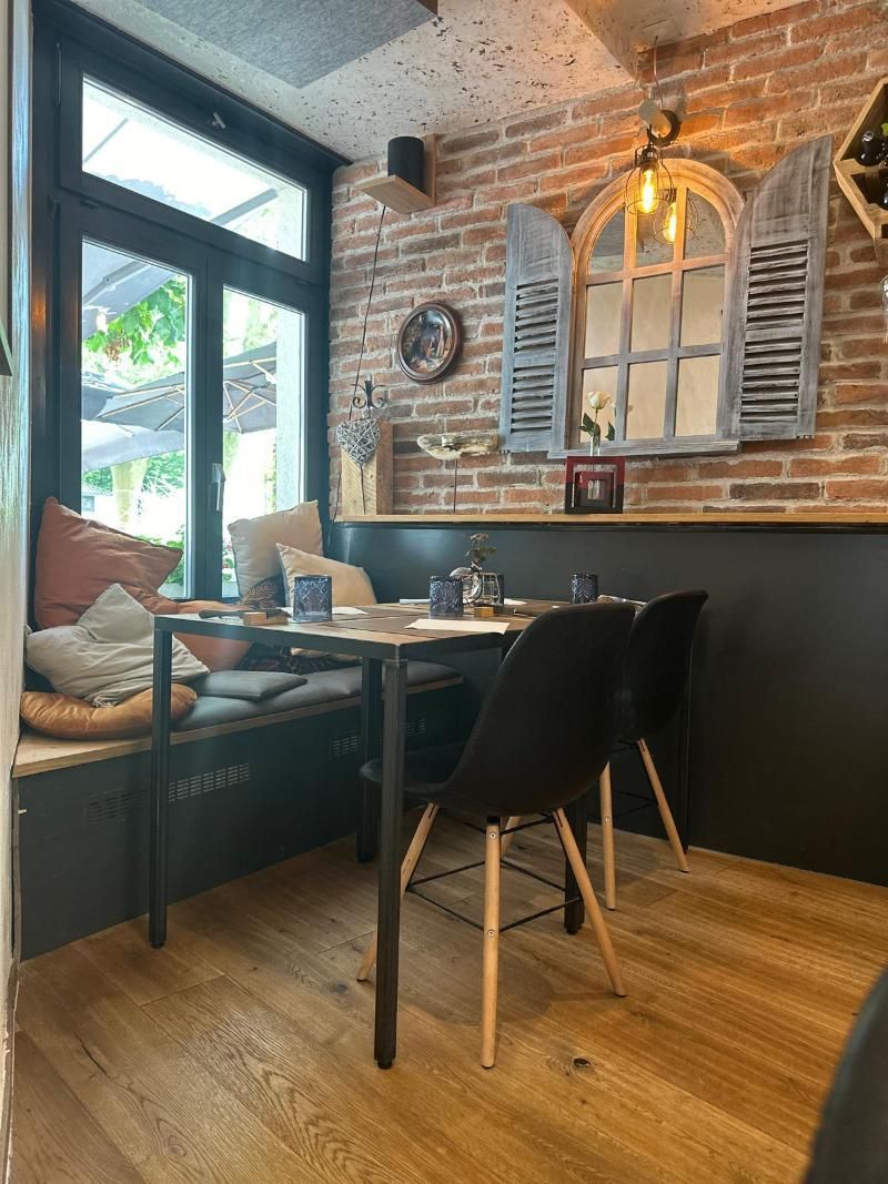 Ein Tisch und Stühle in einem Restaurant mit einer Backsteinmauer