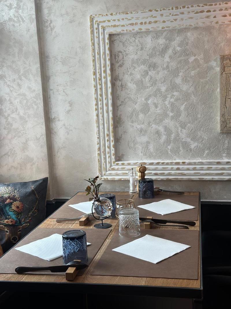 Ein Tisch in einem Restaurant mit einem Bild an der Wand dahinter