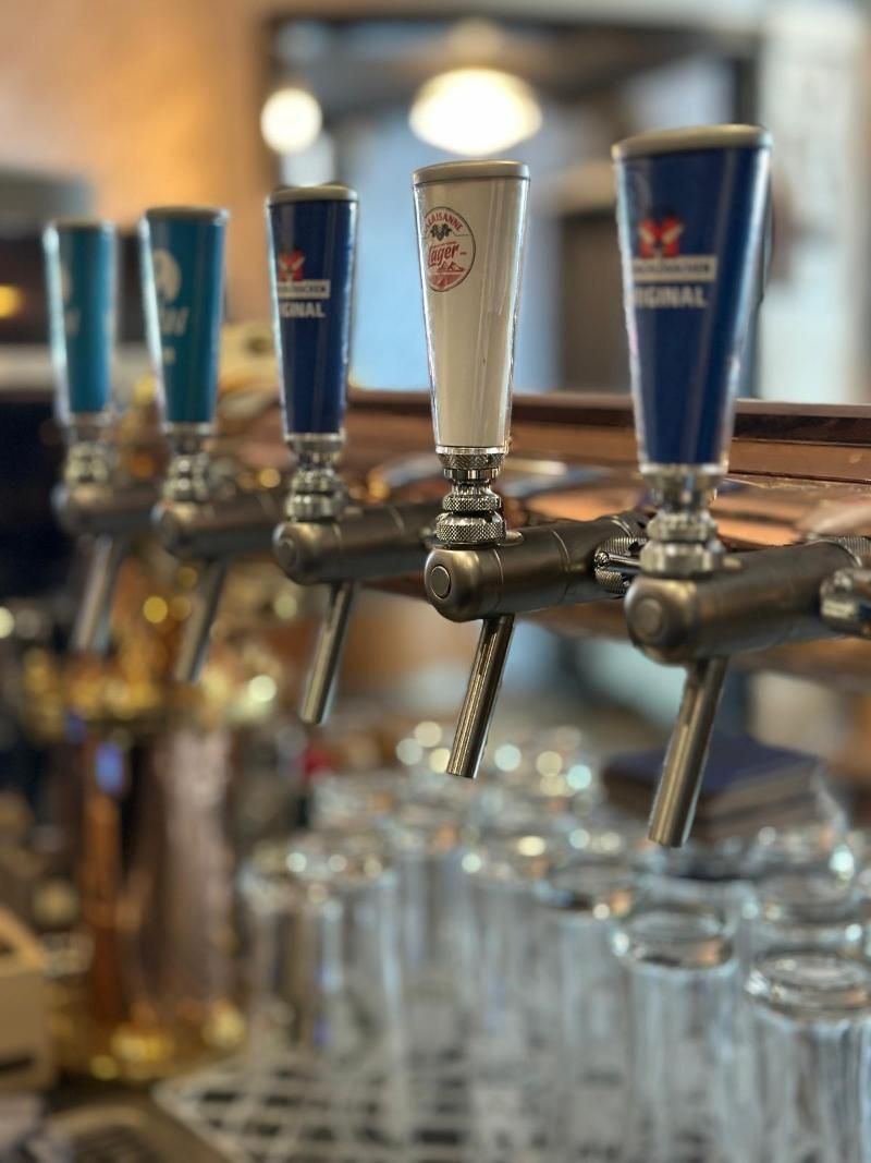 Auf einer Bar sind mehrere Zapfhähne für Bier aufgereiht.