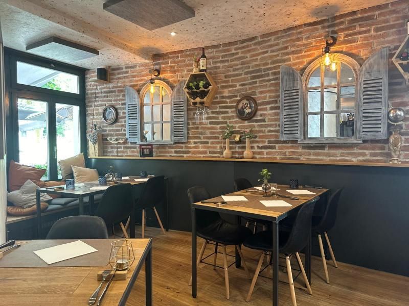 Ein Restaurant mit Tischen und Stühlen und einer Backsteinwand.