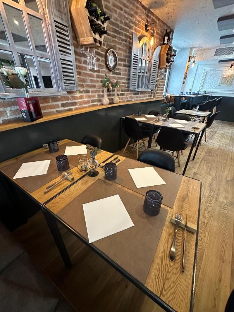 Ein Restaurant mit Tischen und Stühlen und einer Backsteinmauer