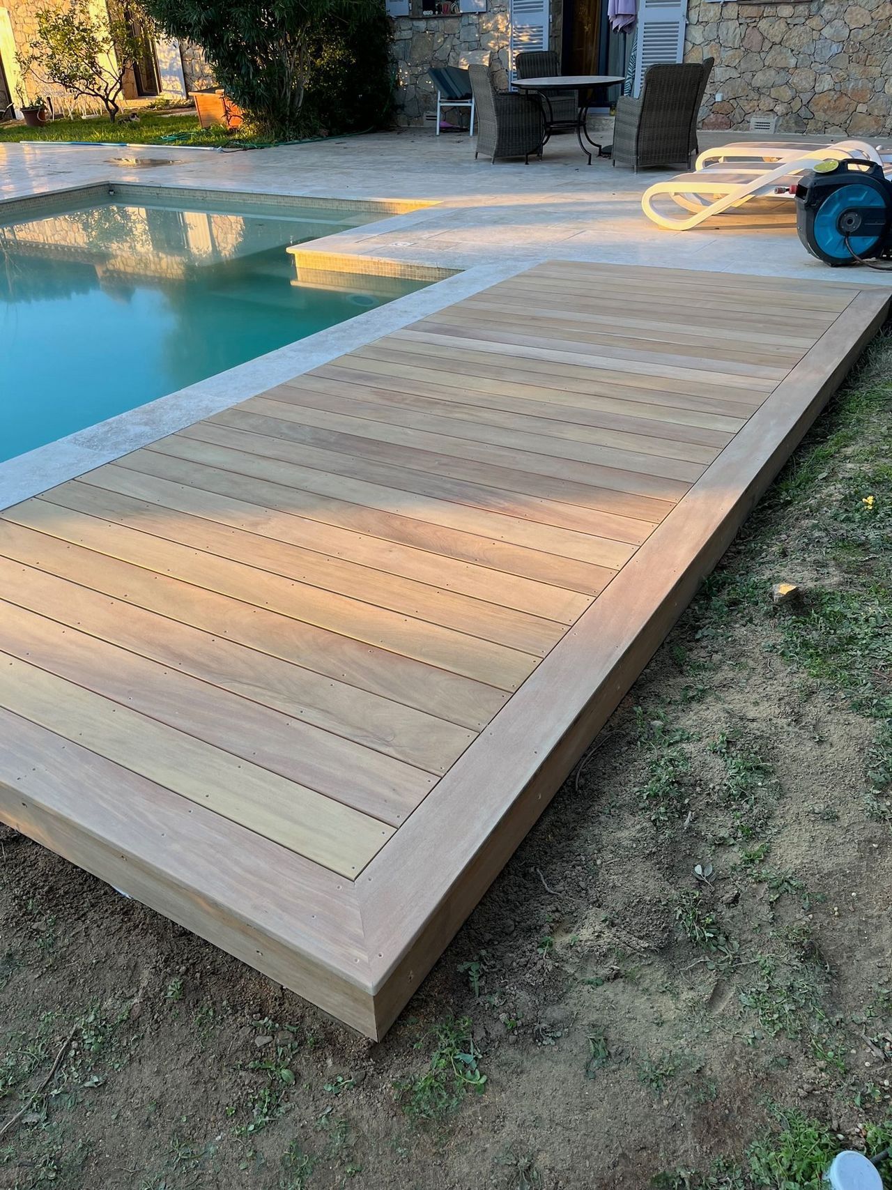 Photo d'une terrasse en bois à coté d'une piscine