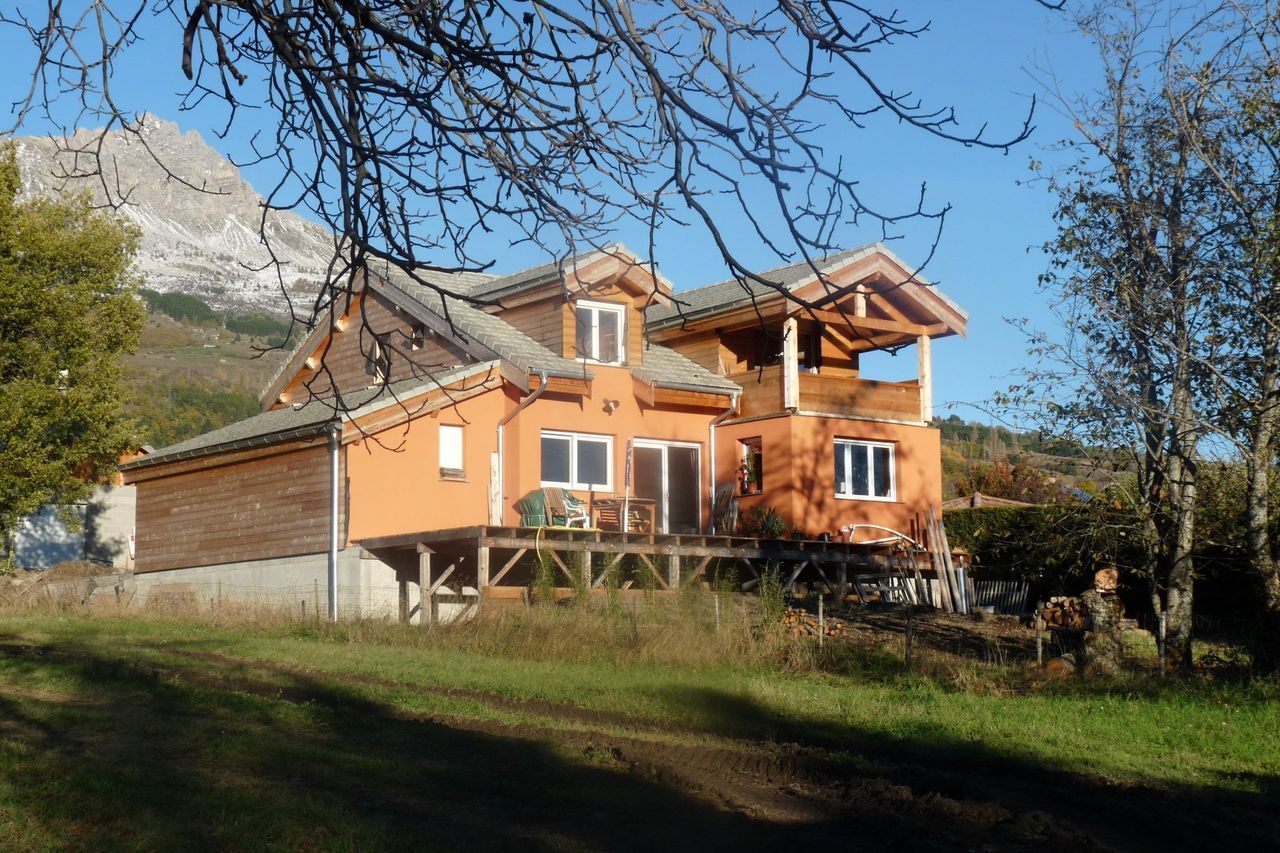 Photo d'une maison de couleur orangée avec une terrasse en bois