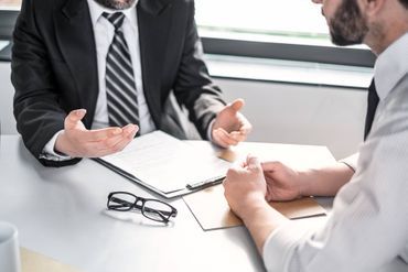 Zwei Männer am Schreibtisch diskutieren