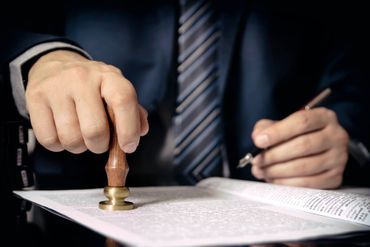 Ein Notar setzt einen Stempel unter ein Dokument