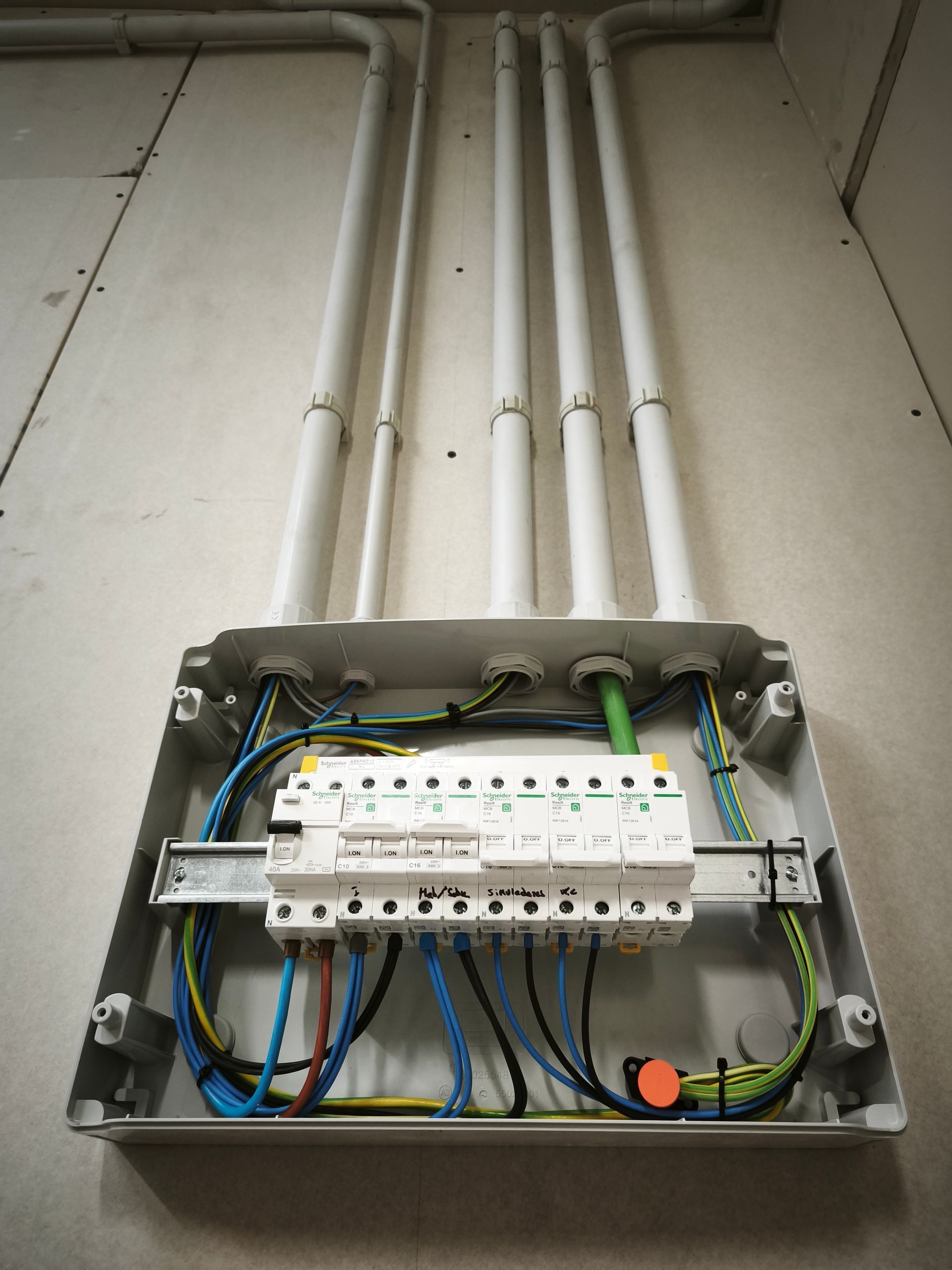 Panel de disyuntores eléctricos abierto con filas de interruptores y una puerta etiquetada.