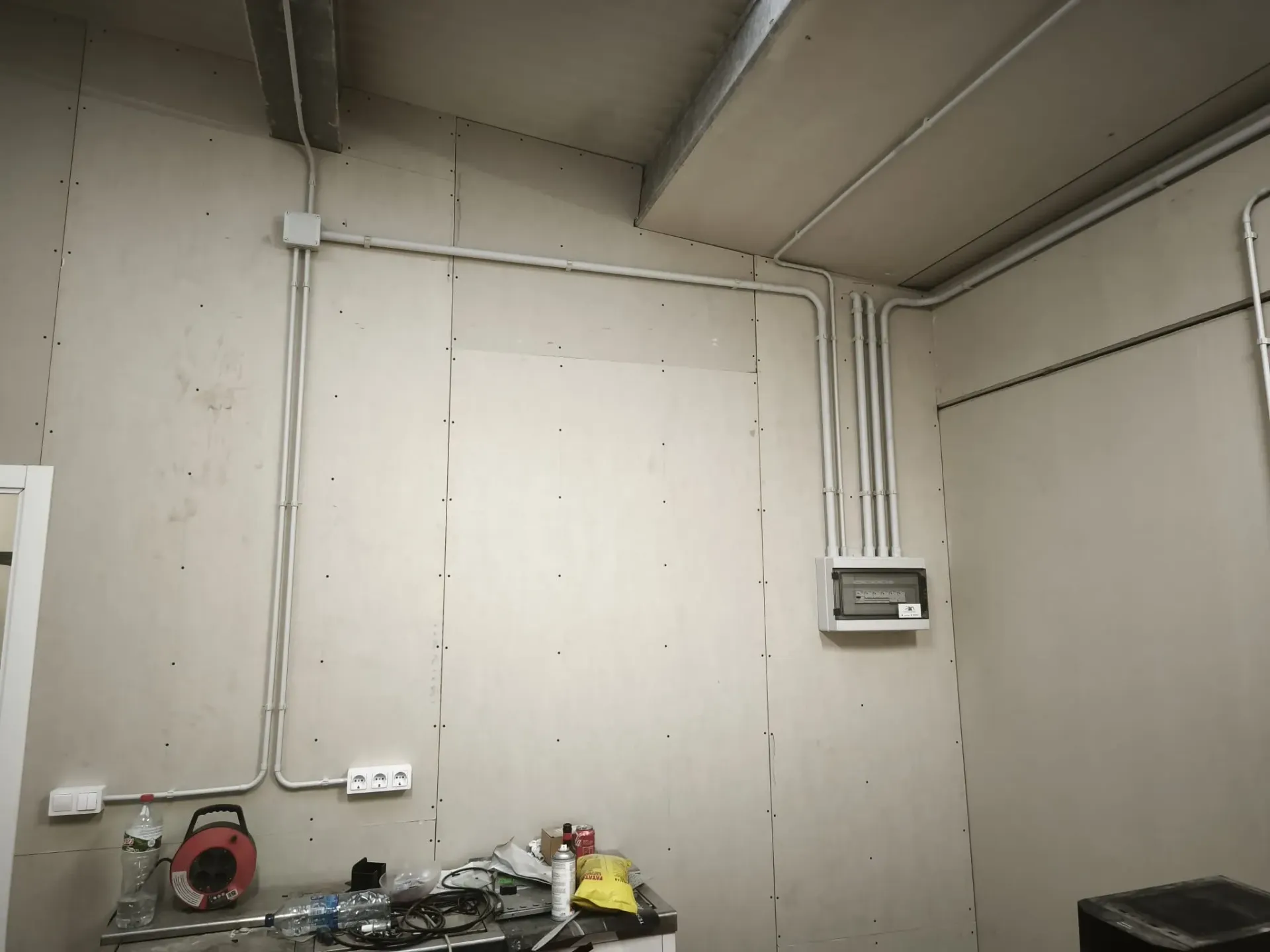 Una pared interior con conductos eléctricos blancos 