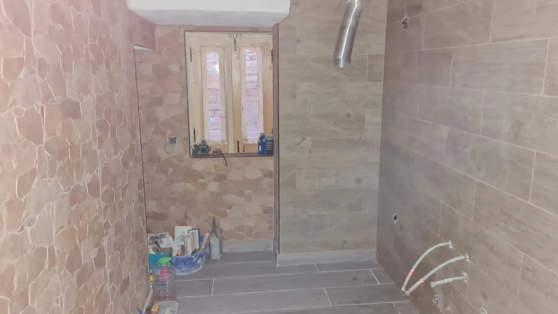 Una pequeña habitación con azulejos que está siendo renovada