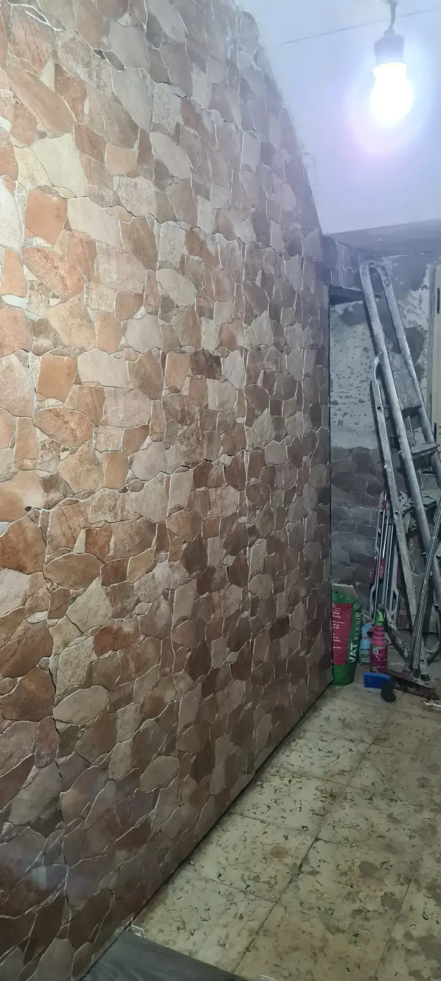 Una pared revestida de azulejos de piedra en una habitación en construcción