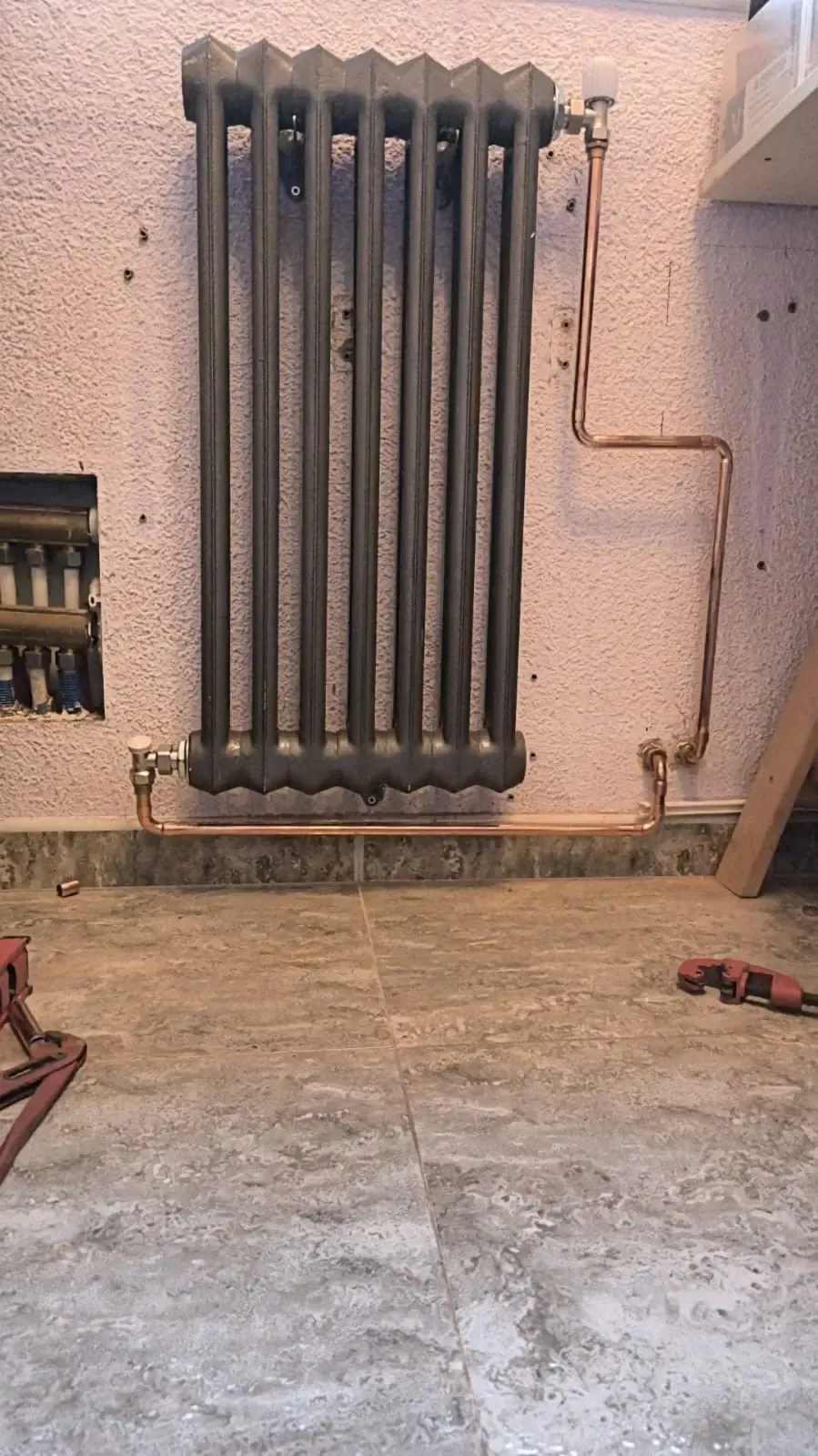 Un radiador vertical, oscuro y con forma de columna