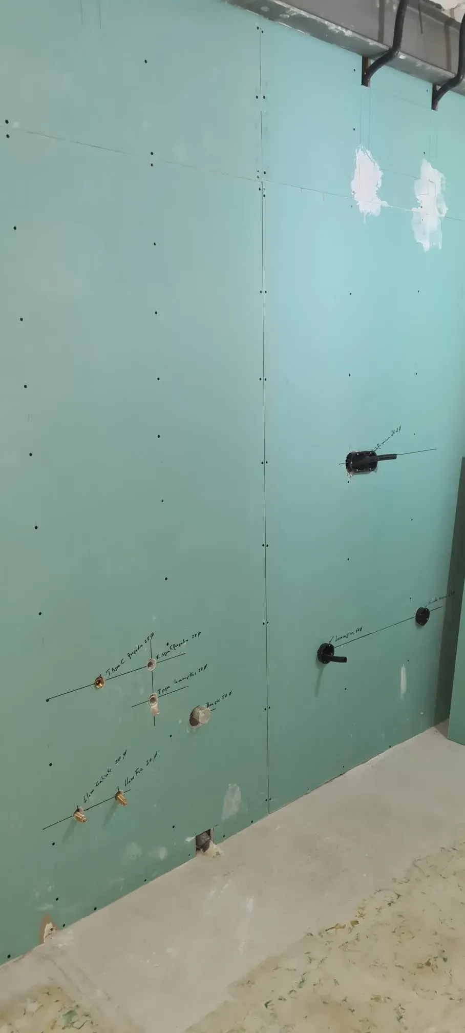 Escaleras de hormigón en construcción en una piscina con azulejos azules y un borde decorativo oscuro en el borde superior.