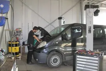 Un homme travaille sur une camionnette dans un garage.