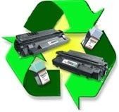 Símbolo verde de reciclaje junto a cartuchos de impresora y cajas de tóner desechados