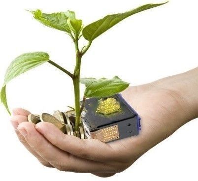 Una mano sostiene una pequeña planta verde junto a un diminuto dispositivo alimentado con energía solar