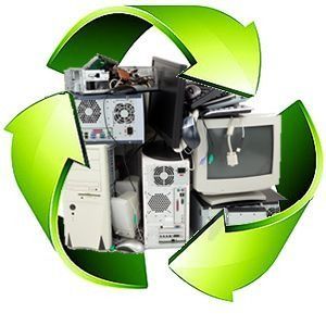 Flechas verdes de reciclaje alrededor de una pila de monitores de computadora y CPU viejos para reciclar residuos electrónicos