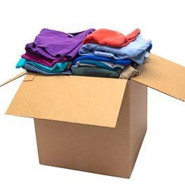 Caja de cartón abierta llena de ropa colorida doblada, con las solapas abiertas.