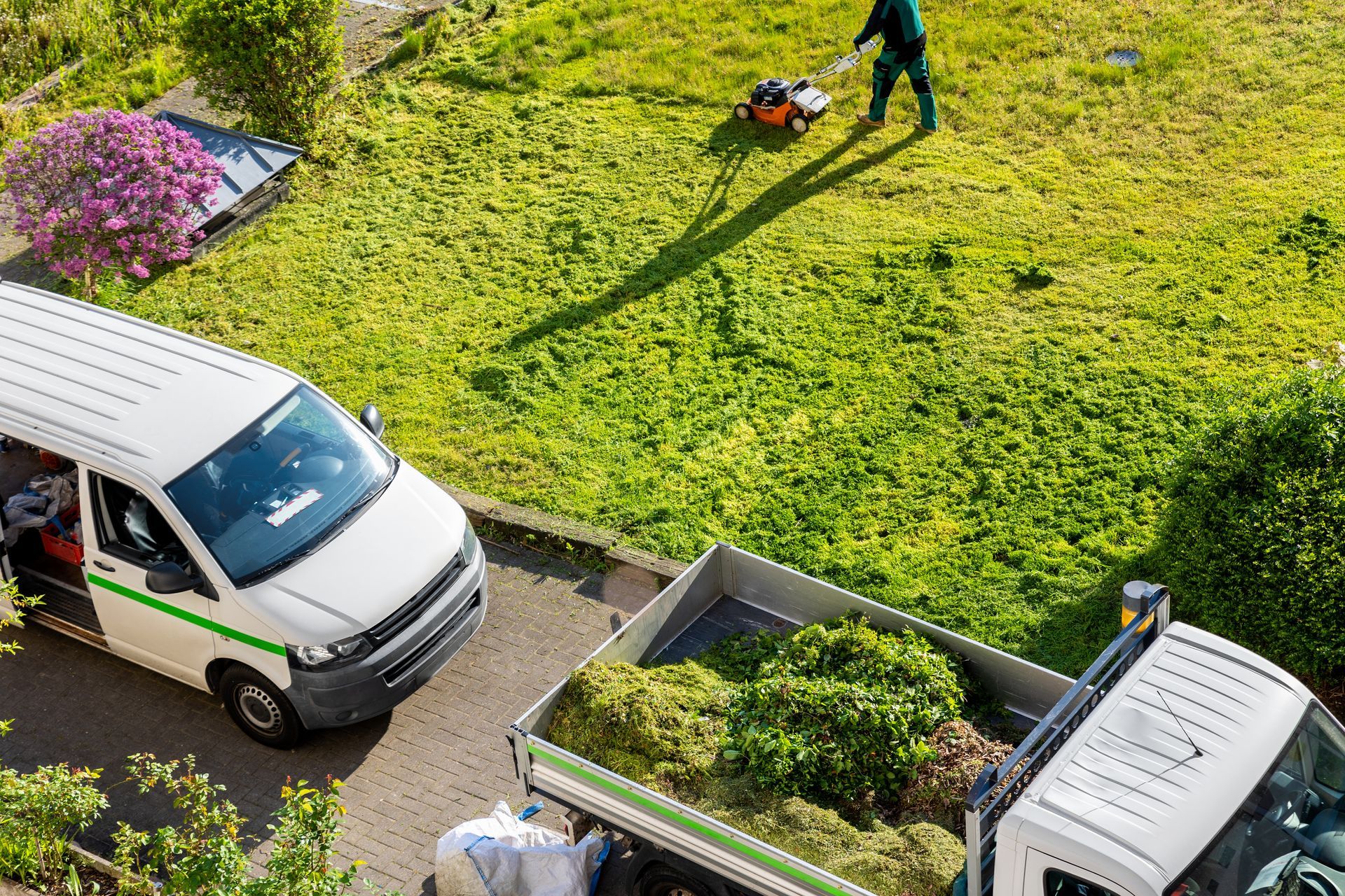 Une personne tondant la pelouse d'un jardin.