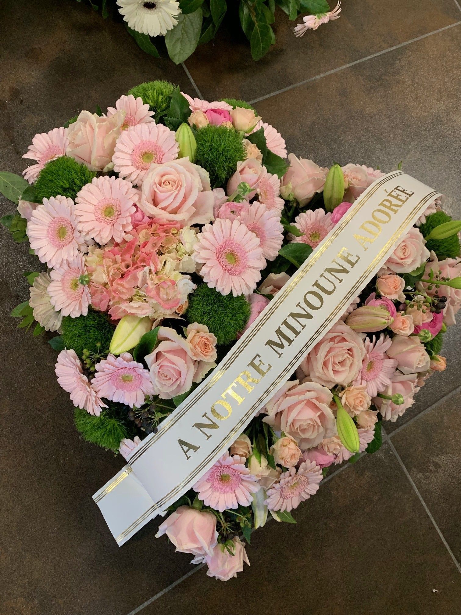 Composition florale pour une tombe composée de fleurs roses