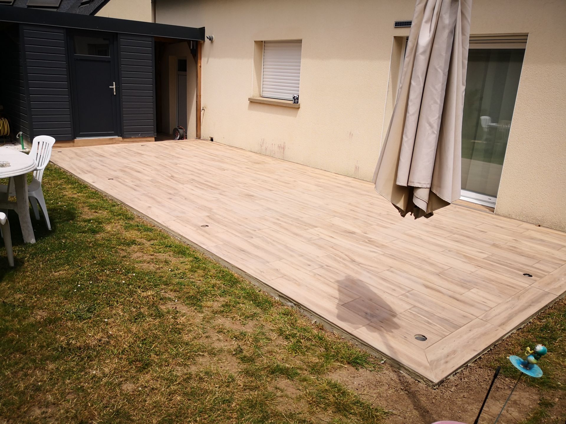 Pose de carrelage sur une terrasse avec imitation bois