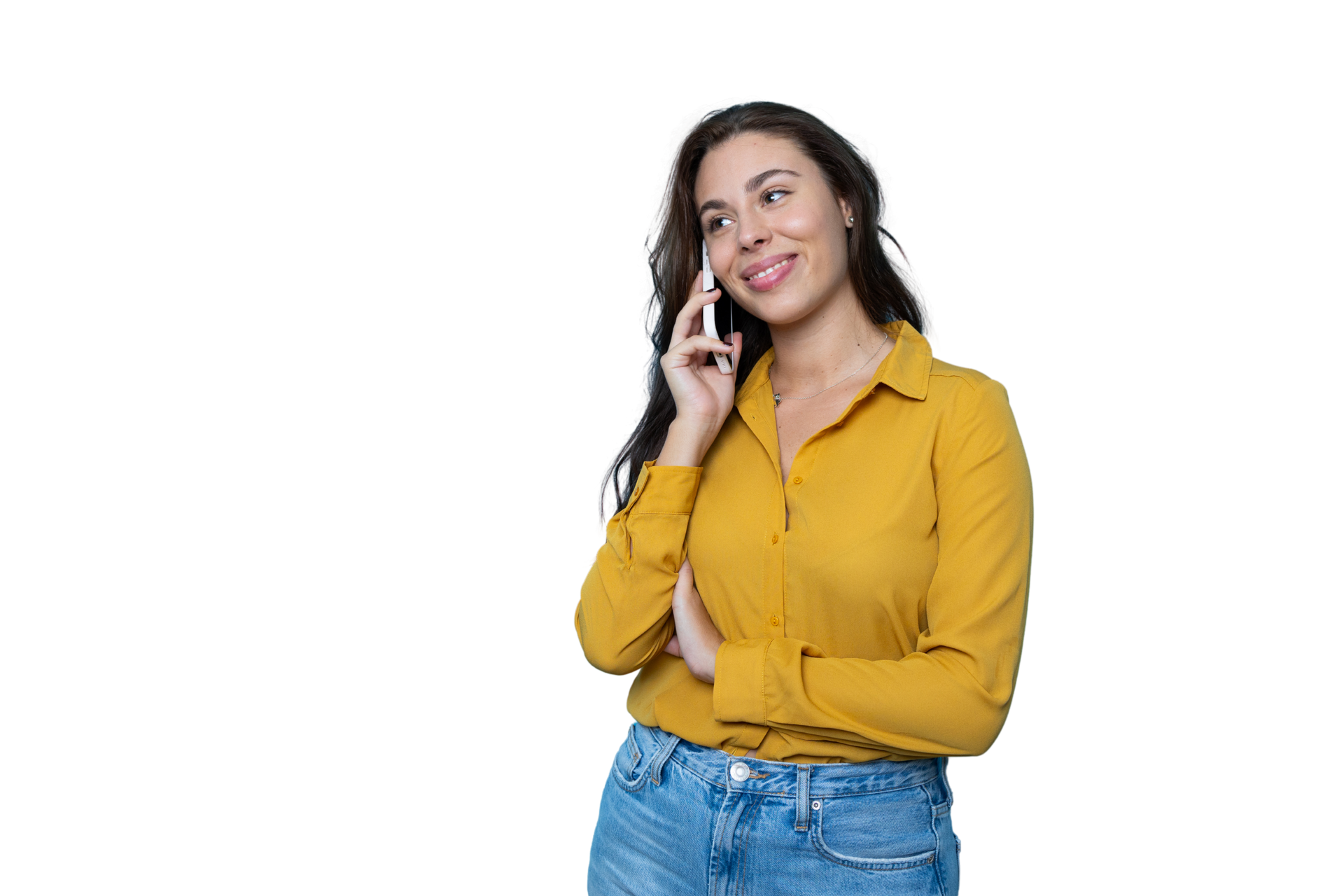 Femme en chemise jaune et jean souriante est en pleine conversation téléphonique.