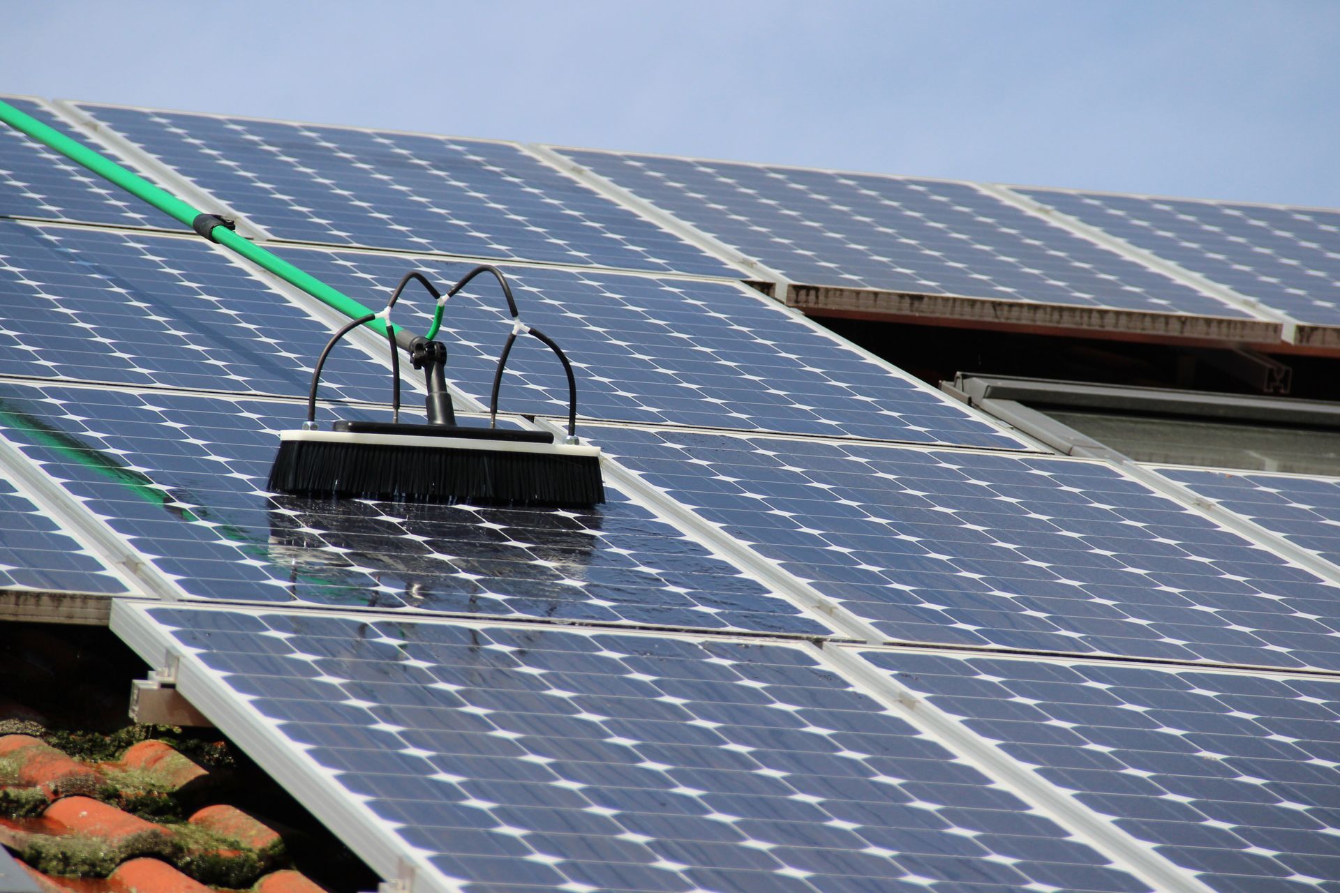 Nettoyage de panneaux solaires avec un balai télescopique.
