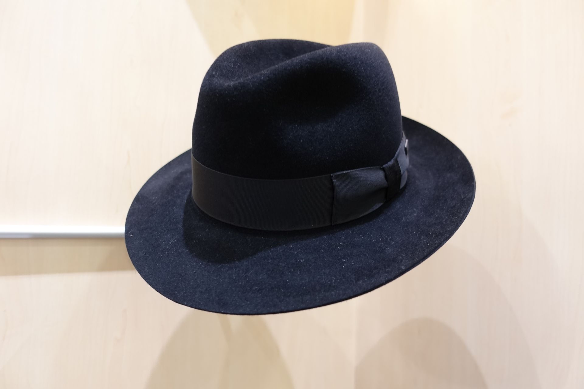 Chapeau fedora noir à ruban, présenté sur fond clair