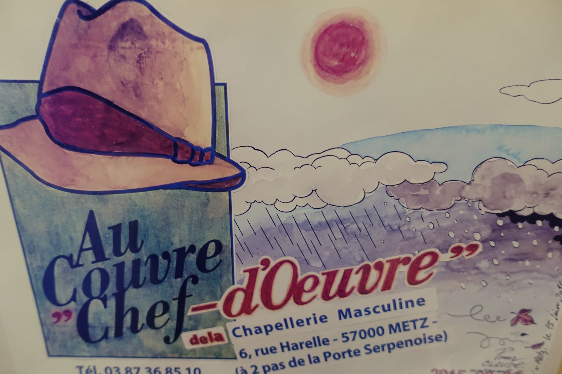 Poster vintage avec un chapeau, le ciel ensoleillé, et du texte “Au Couvre Chef-d’œuvre”