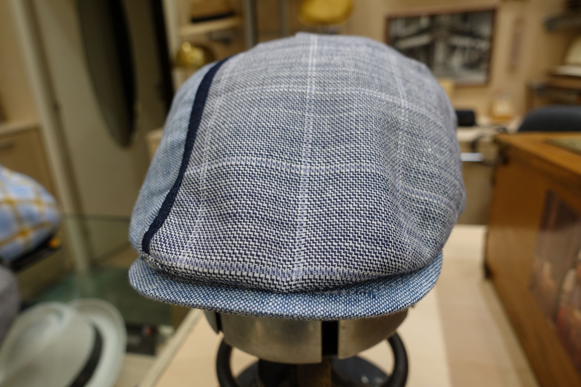 Casquette bleue à motifs posée sur un tabouret dans un intérieur de maison.