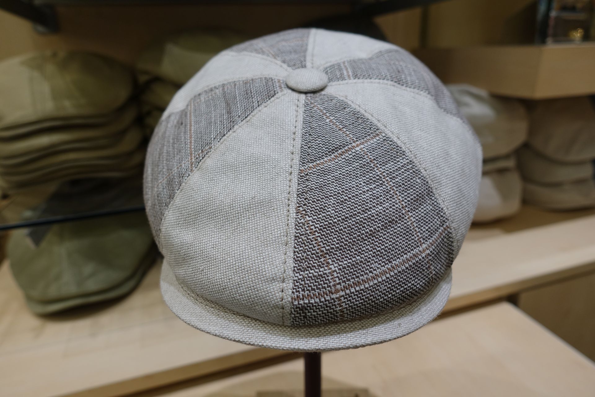 Casquette grise patchwork sur un présentoir dans un magasin