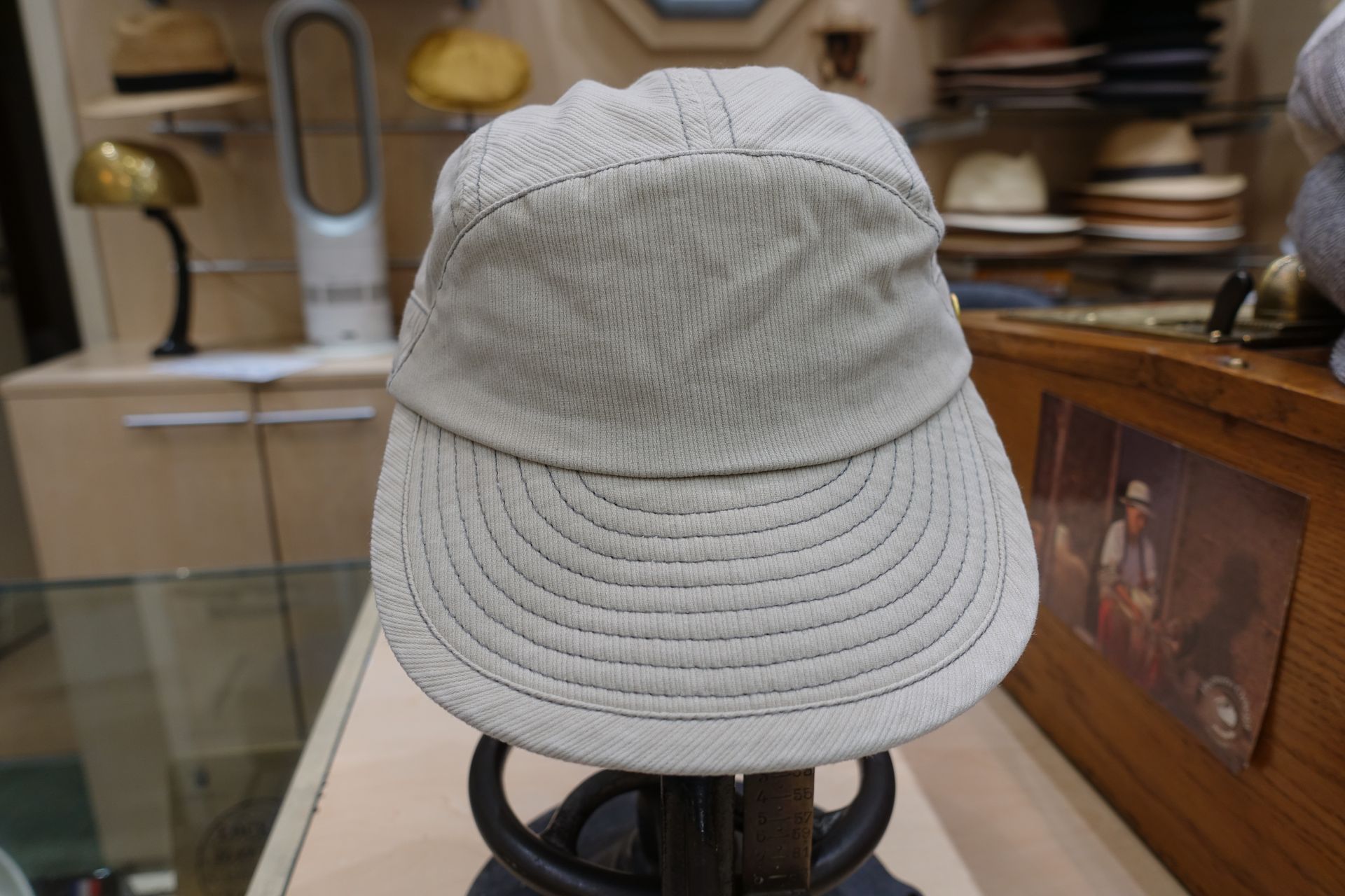Casquette gris clair présentée sur un présentoir en vitrine