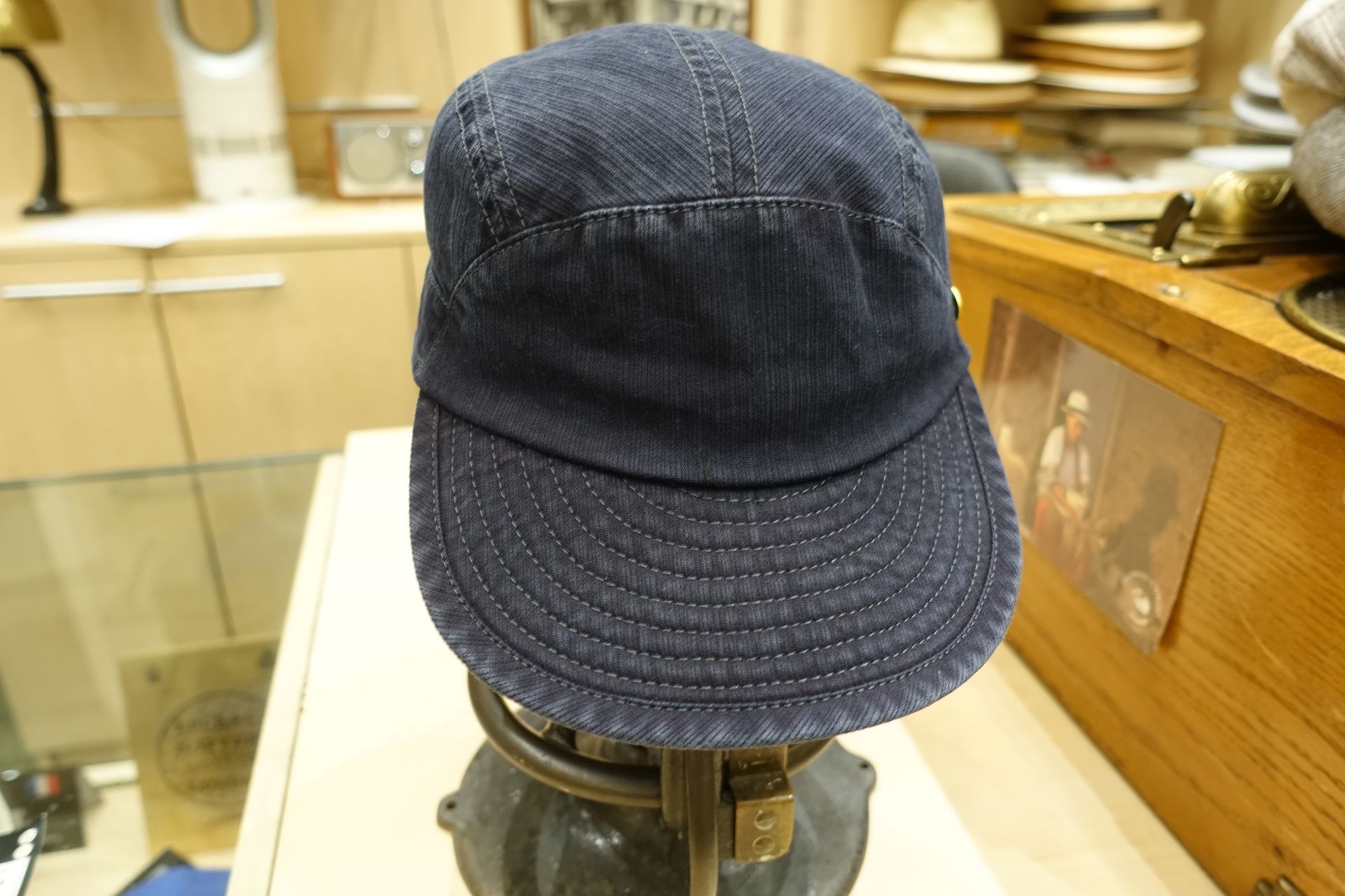 Casquette en denim bleu sur un présentoir dans un magasin.
