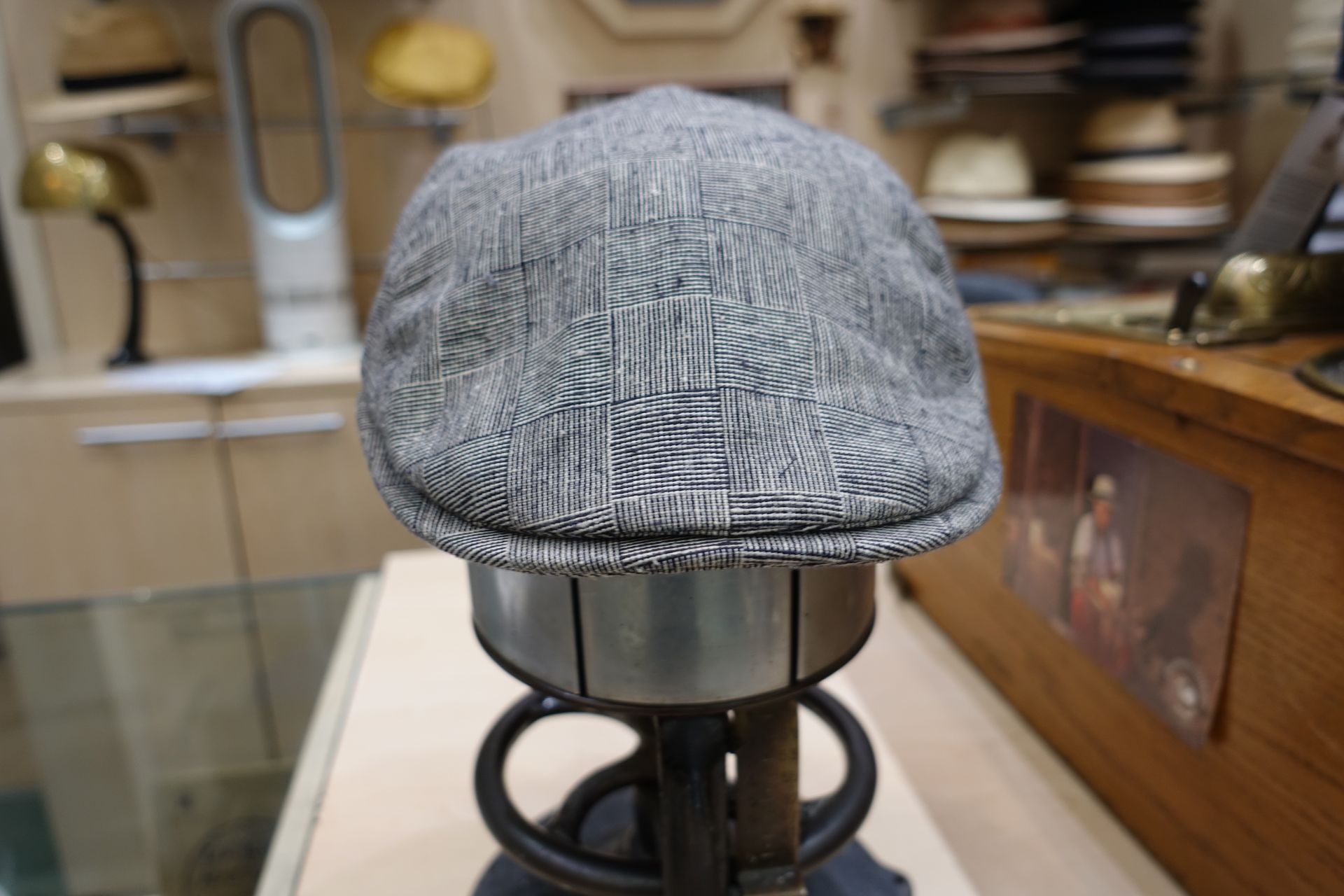Casquette plate grise à chevrons sur un présentoir dans un magasin