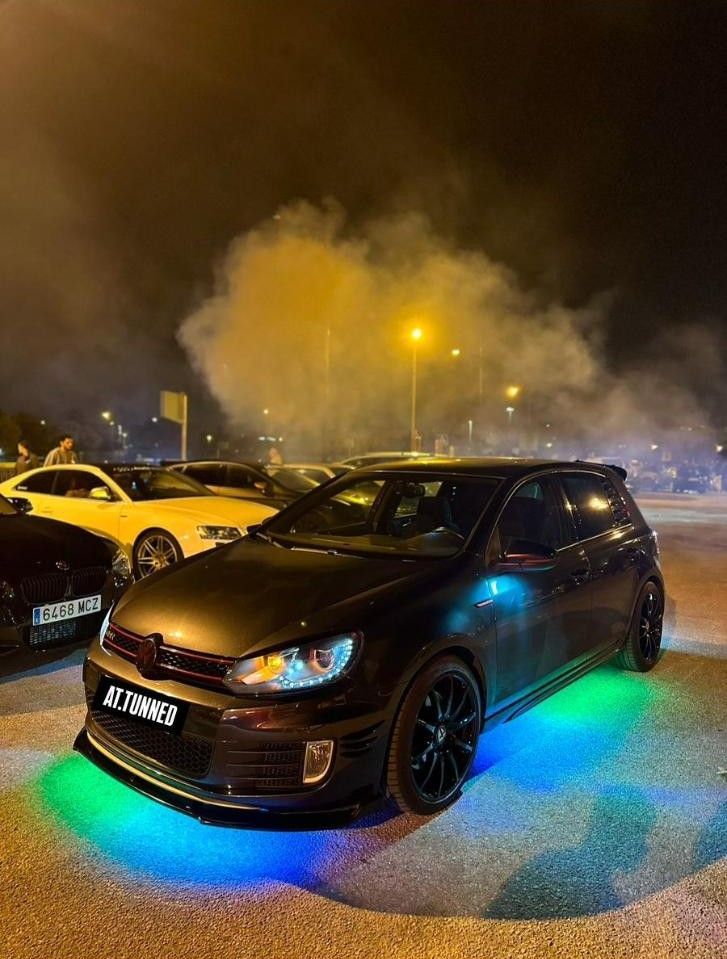 Automóvil negro con luces incandescentes haciendo un burnout por la noche.